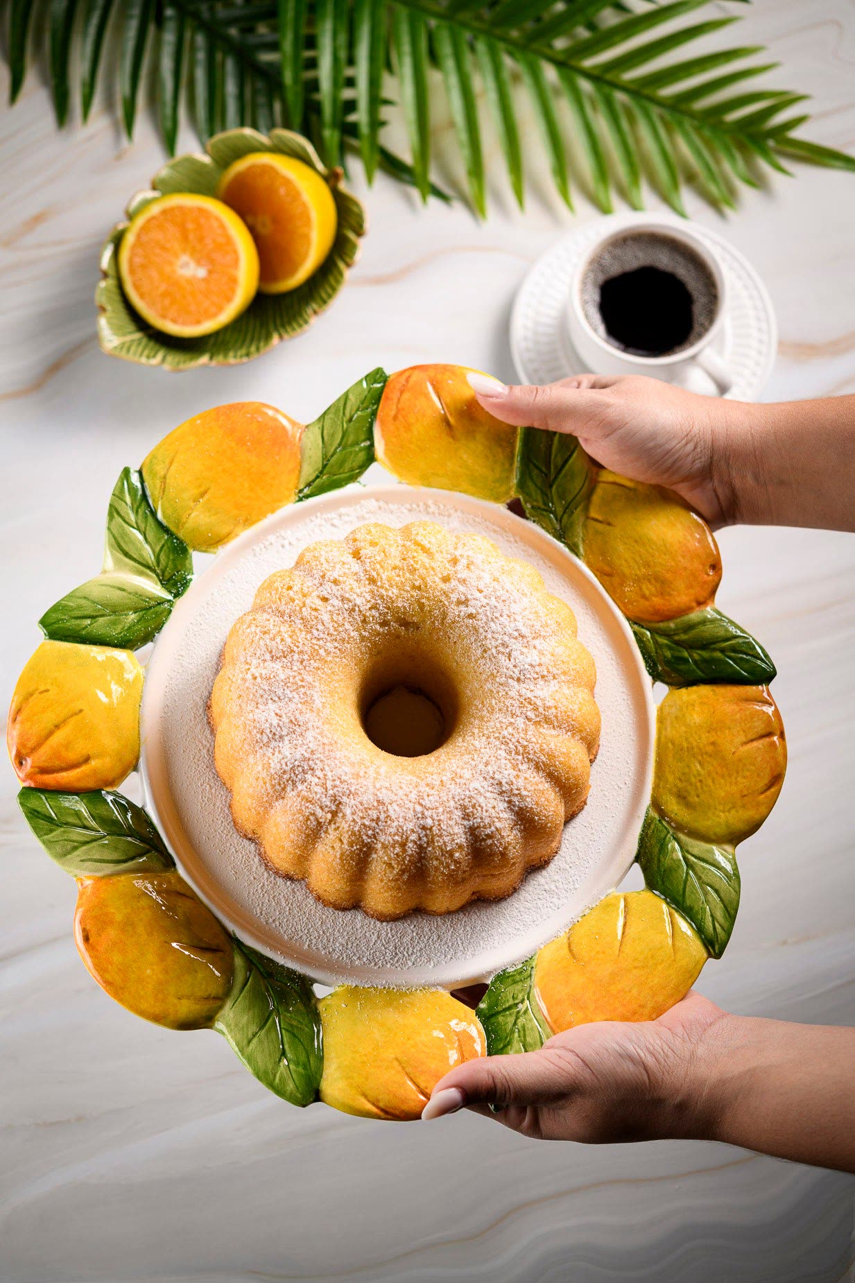 Bolo de laranja polvilhado, servido ao lado de laranjas